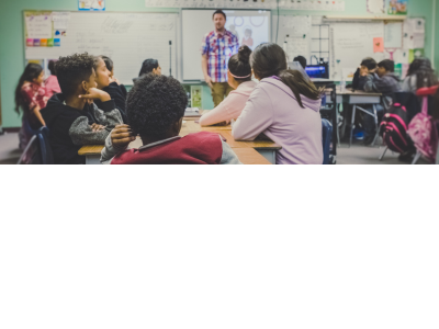 A male teacher presenting to a classroom of teenage students